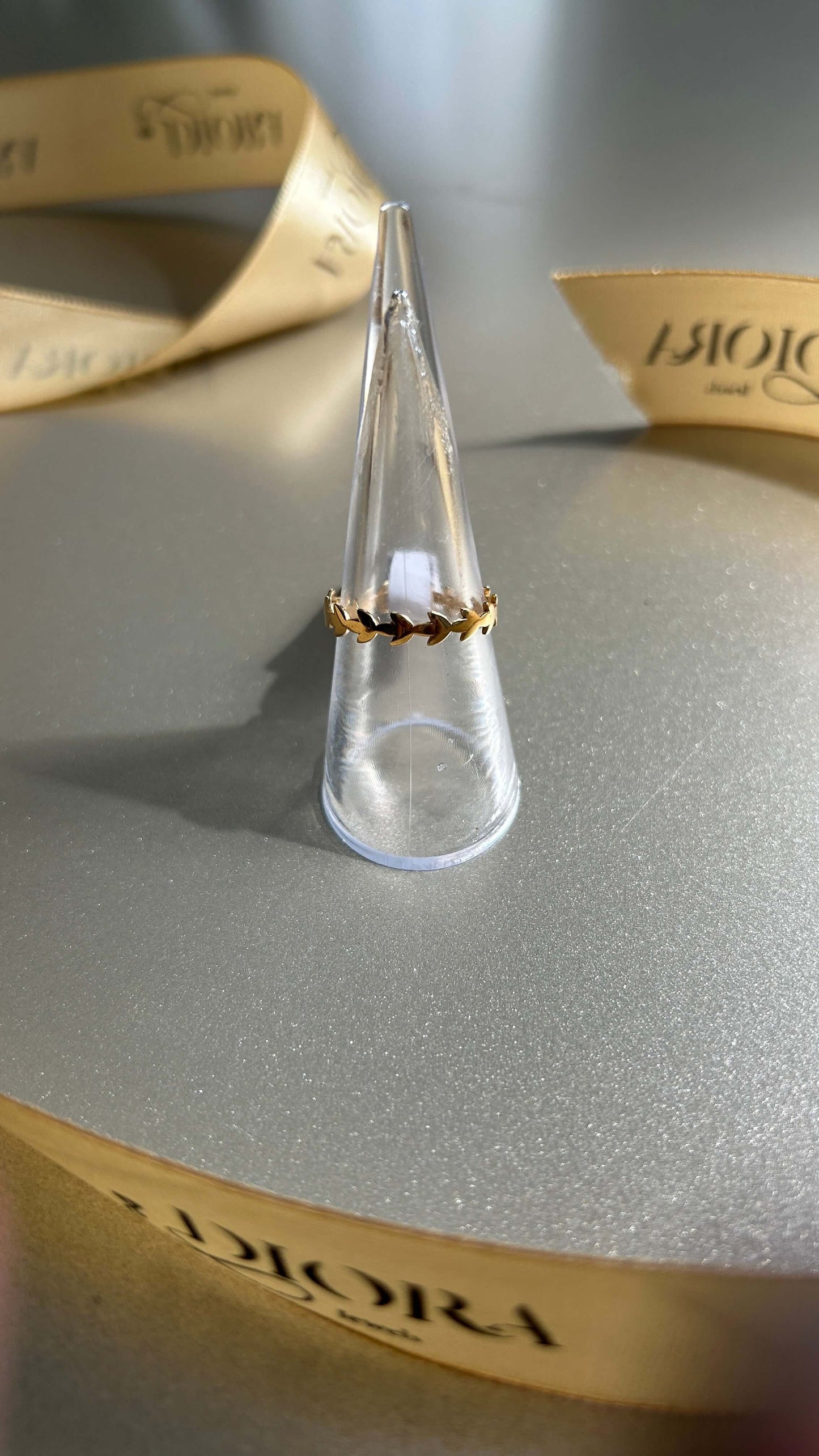 Elodie Ring displayed on a ring holder, featuring an olive leaf design in 18K solid gold.