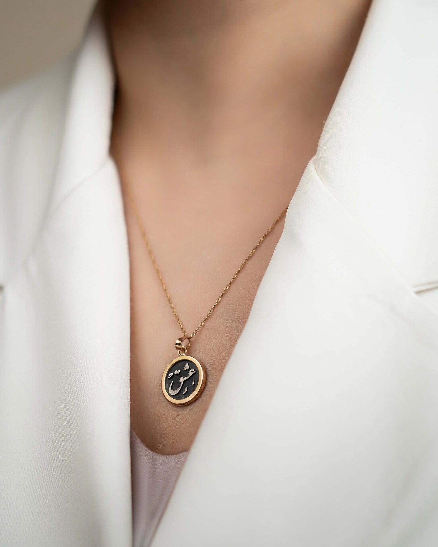 Silver and Gold Pendant - Eshgh worn on a person with a white blazer, showcasing the intricate design.