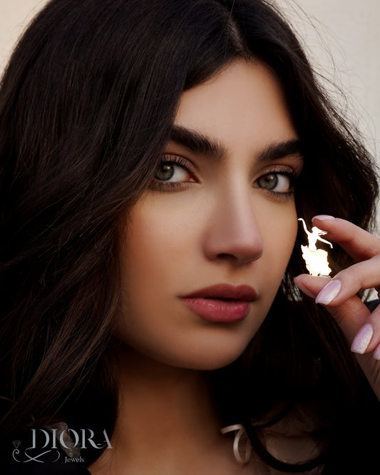 A woman showcasing an 18K solid gold and silver pendant with a white design, branded by Iran Banoo.