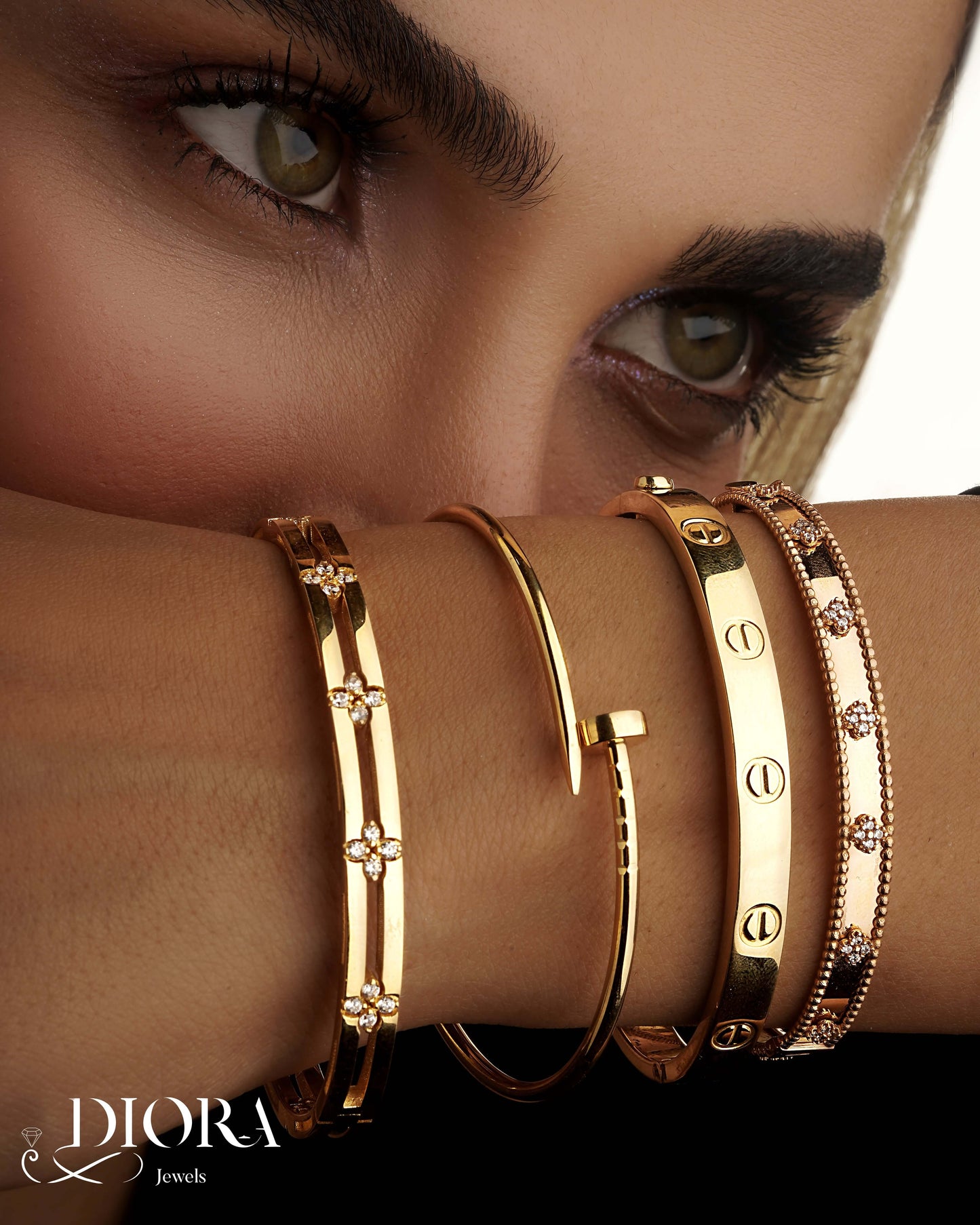 Close-up of a woman's arm wearing gold Dior bracelets.