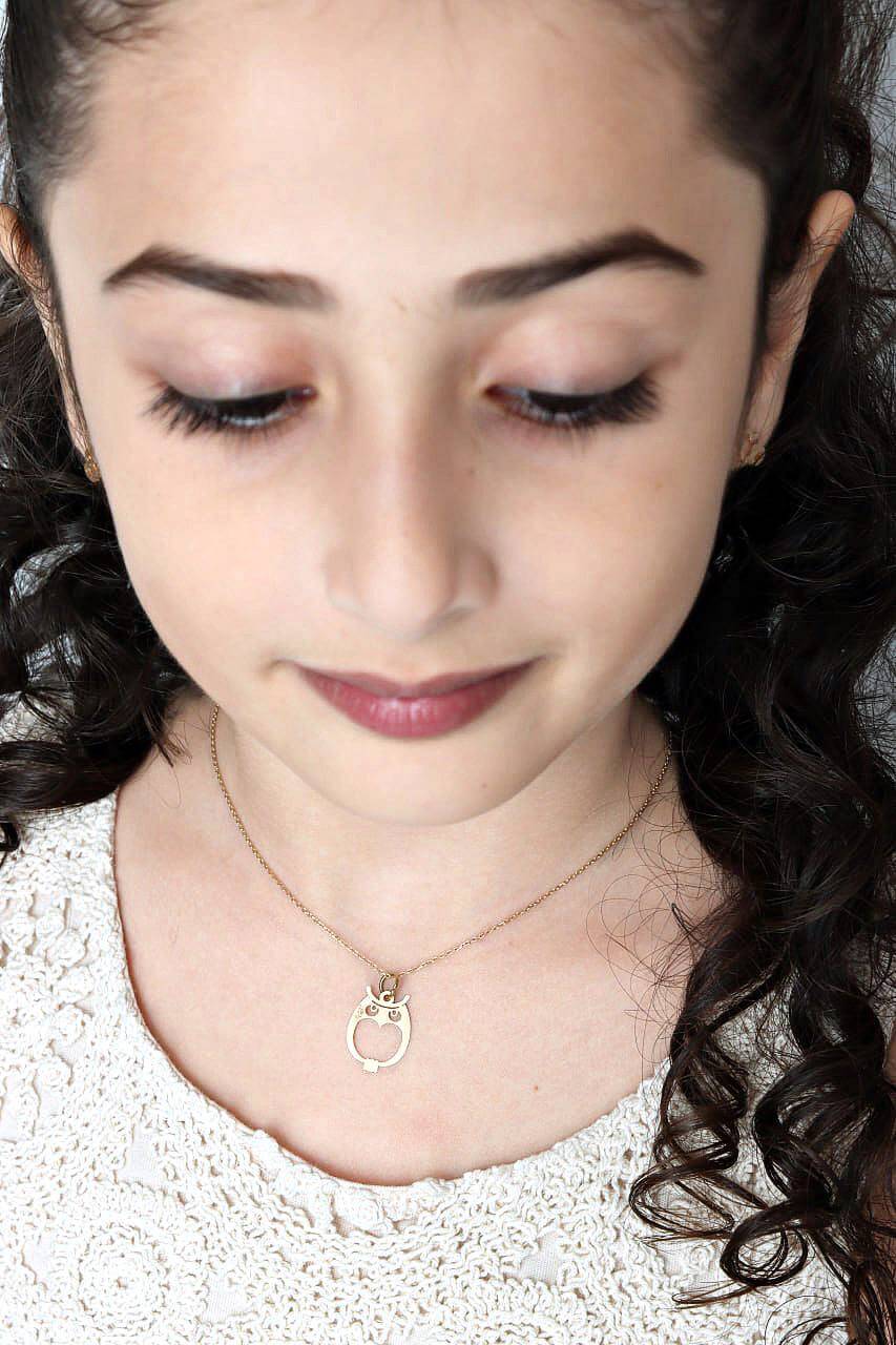 Owel Pendant worn by a young girl, showcasing the minimalist 18k gold design.