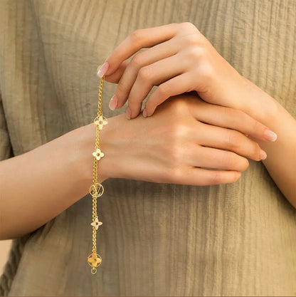 Gold bracelet with decorative elements on a neutral background