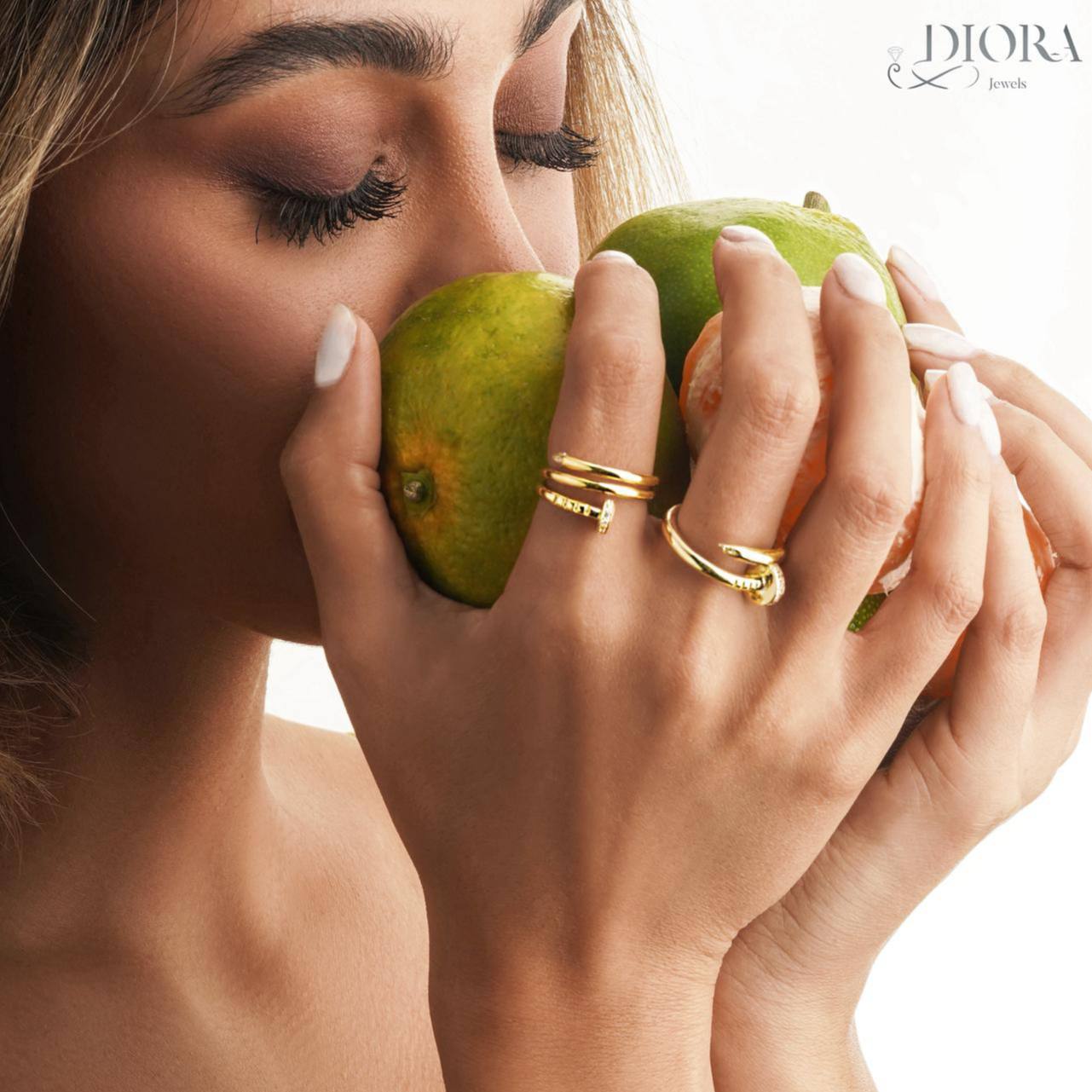 Close-up of a woman's face holding two green apples with 'Dior' branding.